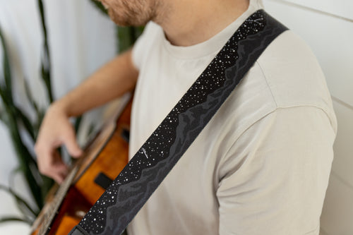Black midnight mountain guitar strap featuring mountain range and stars. 
