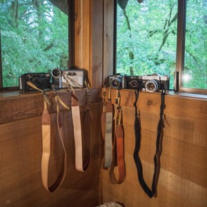collection of wildtree solid colored camera straps sitting on window