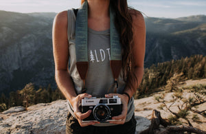 Women wearing Wildtree pinetree camera strap attached to camera