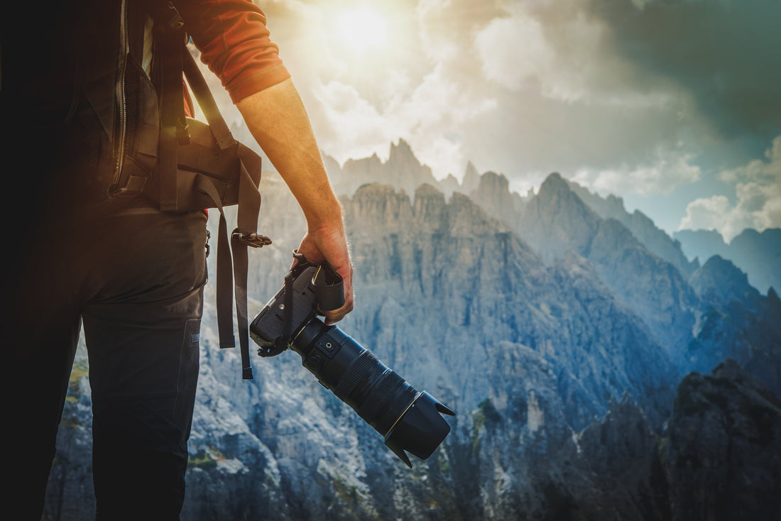 Man holding camera looking out towards mountains