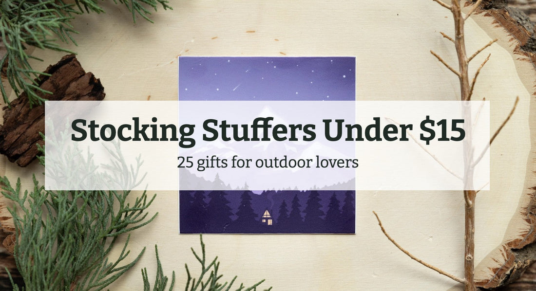 Stocking Stuffers Under $15: 25 gifts for outdoor lovers, title over a Wildtree Cozy Retreat sticker of a snowy mountain cabin on a wood slice with evergreen sprigs