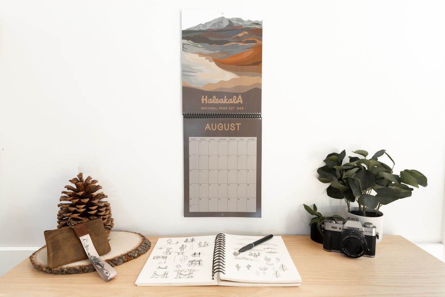 2025 calendar hanging on wall. Haleakala National park illustration for August.