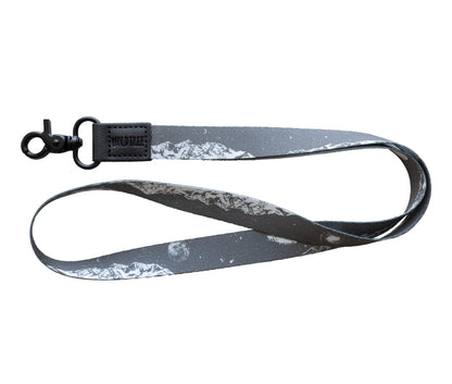 A gray neck lanyard with a white mountain and celestial design, including a planet, curved into a U-shape on a plain white background.