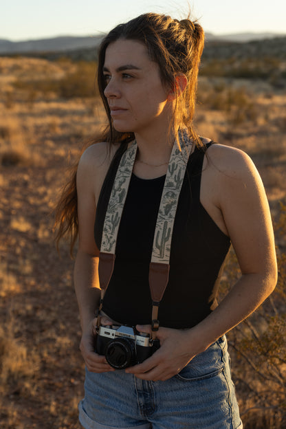 Women wearing Western landscape camera strap looking off in to the sunset