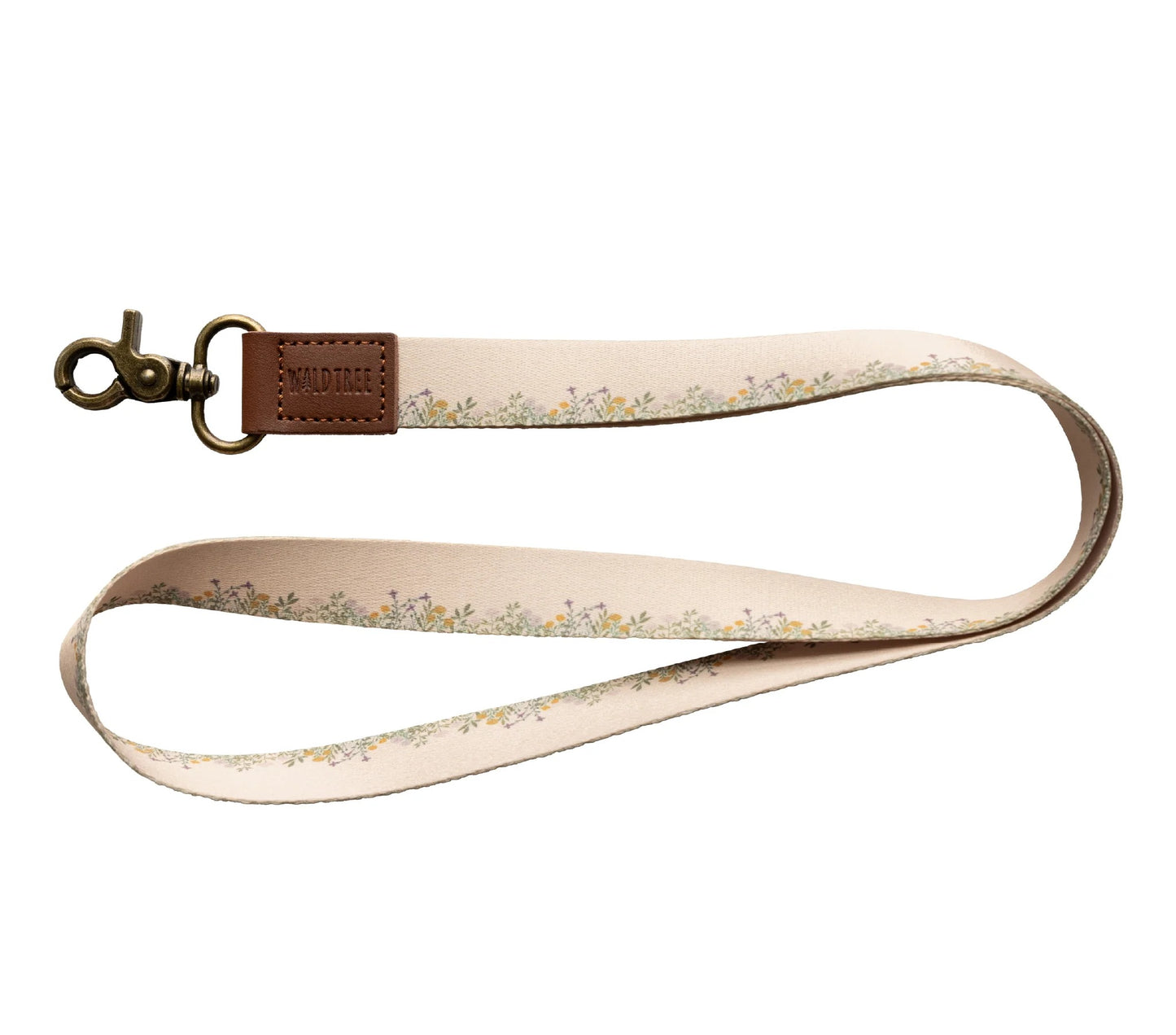 A "Wildtree flower field neck lanyard" is displayed against a stark white background. The lanyard features a tan fabric strap adorned with a delicate pattern of small yellow and green flowers and leaves running along its length.