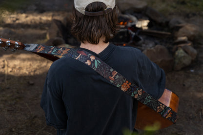 Forest Foliage guitar strap outside around a campfire playing guitar