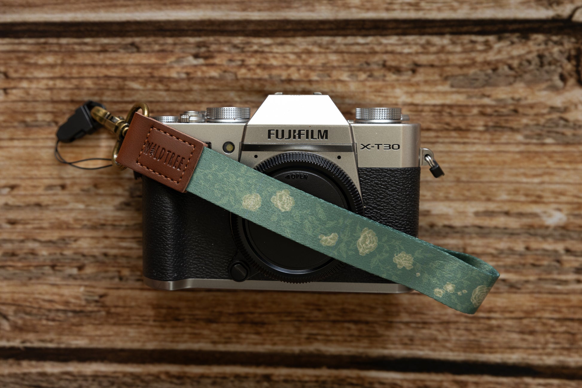 Green Wristlet keychain printed with green vines and yellow flowers connected to camera