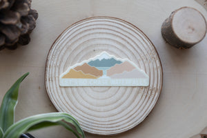 sticker design featuring colorful mountains and a waterfall with the words "Let's Go Chase Waterfalls" 