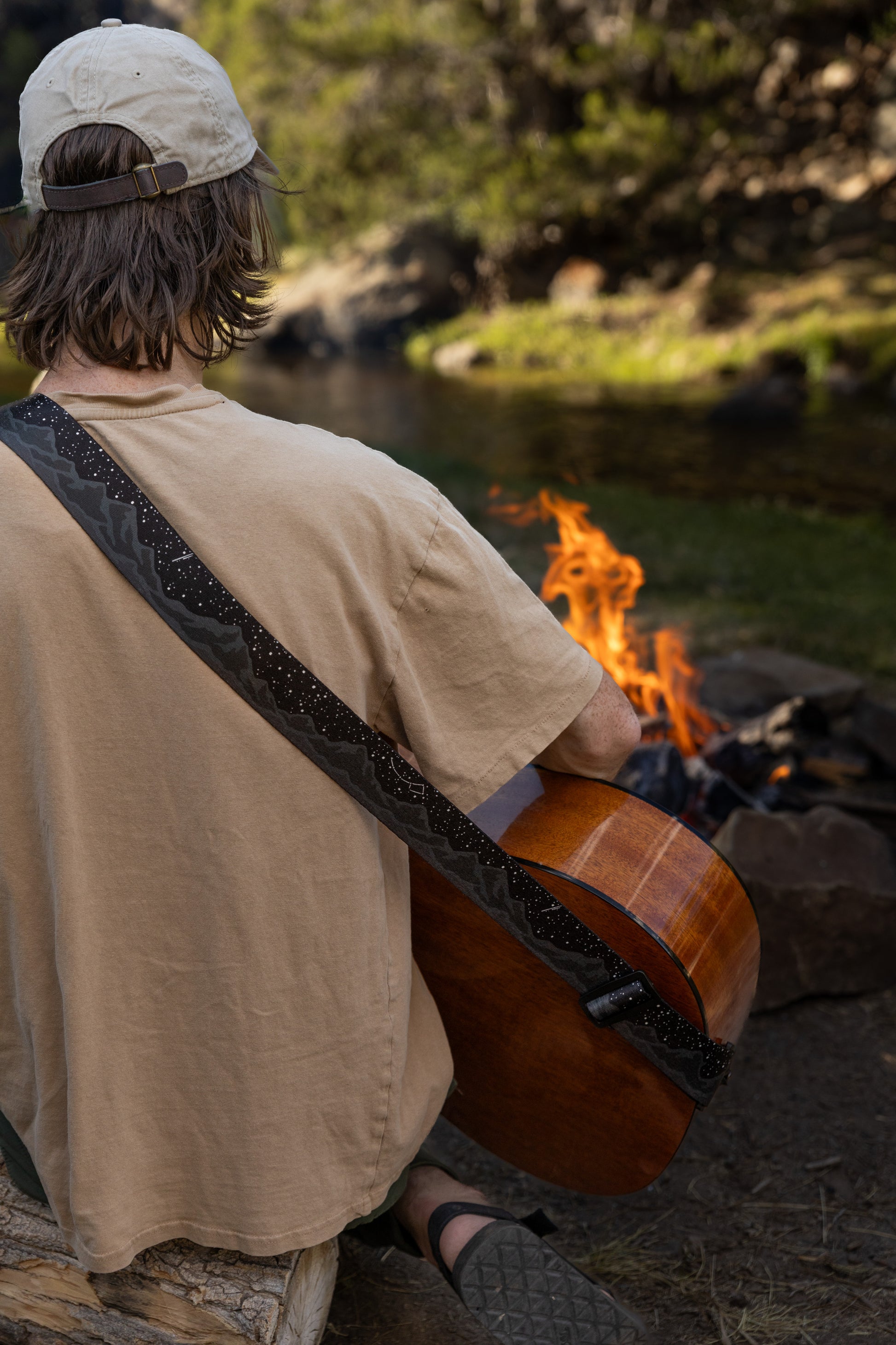 Midnight-mountain guitar strap outside around a campfire playing guitar