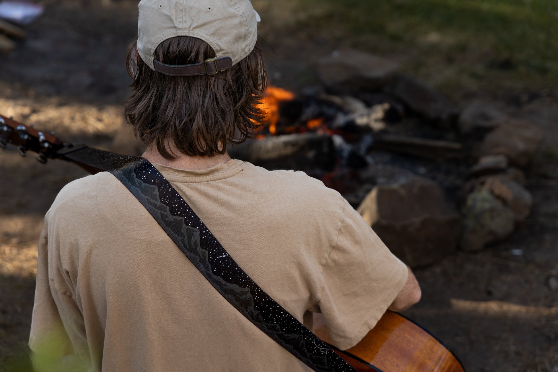 Midnight-mountain guitar strap black and white design  outside around a campfire playing guitar