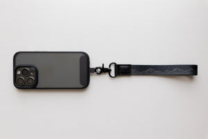Black midnight mountain keychain attached to phone case