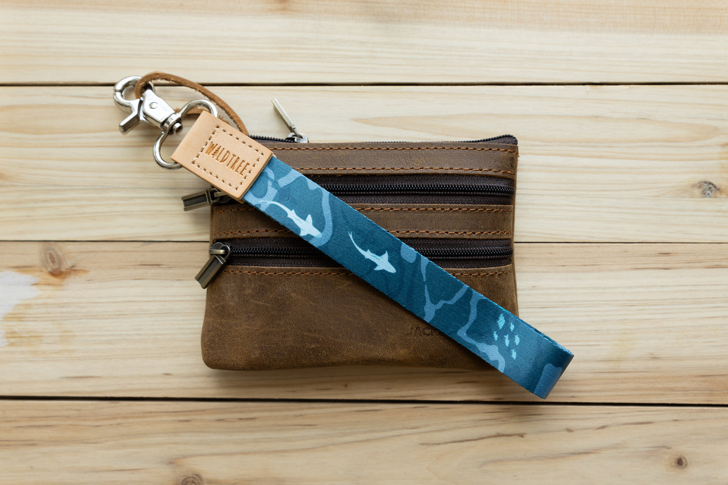 Ocean design wristlet keychain attached to brown leather wallet