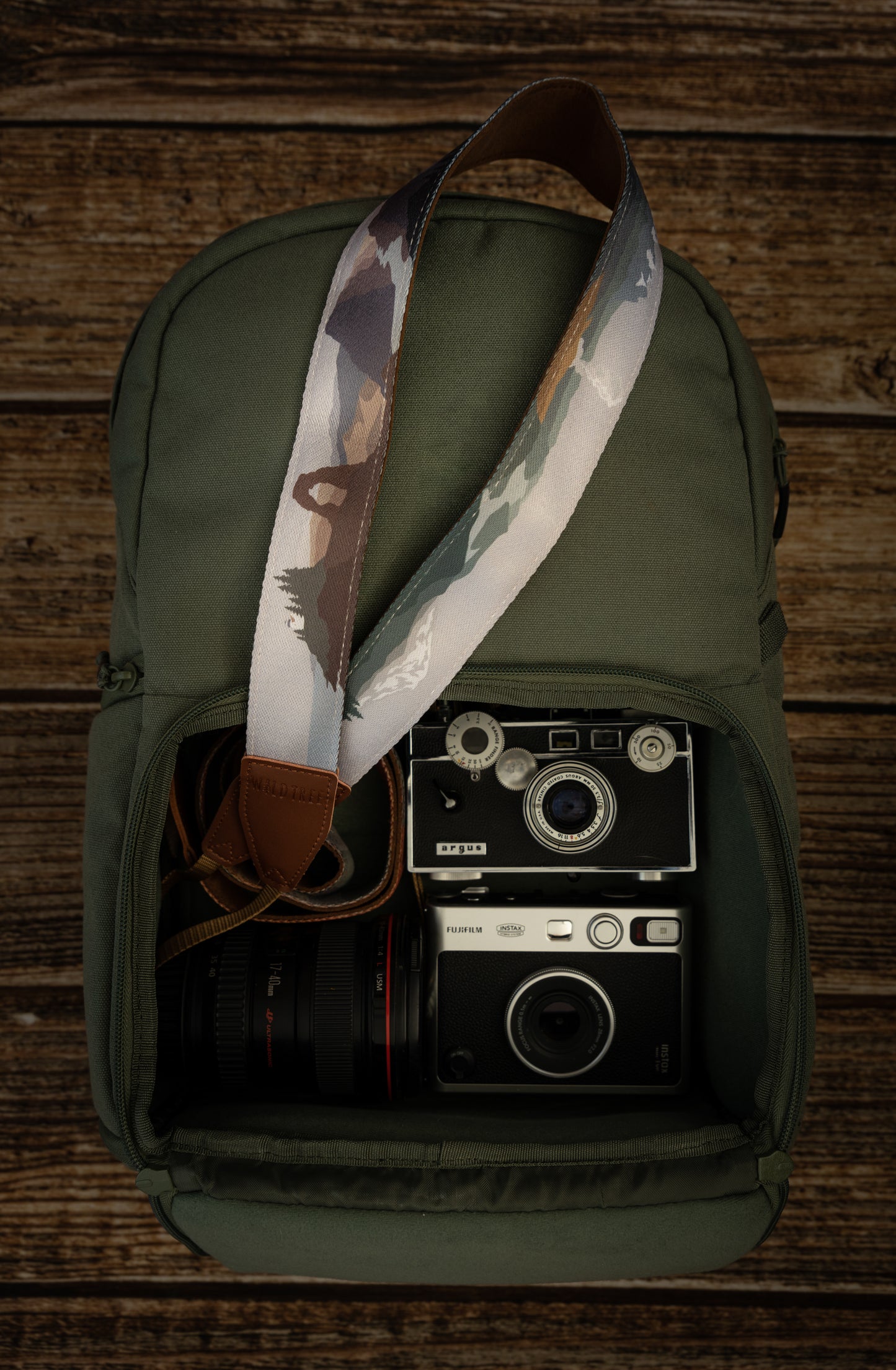 National parks camera strap in color laying out on green brevite back pack.