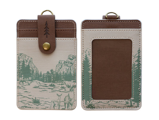 A flat-lay studio shot displaying the front and back layout of the cream Yosemite mountain ID badge holder isolated on a white background. It highlights the clean structure of the card pockets, window pane, and the small debossed pine tree on the brown snap strap.