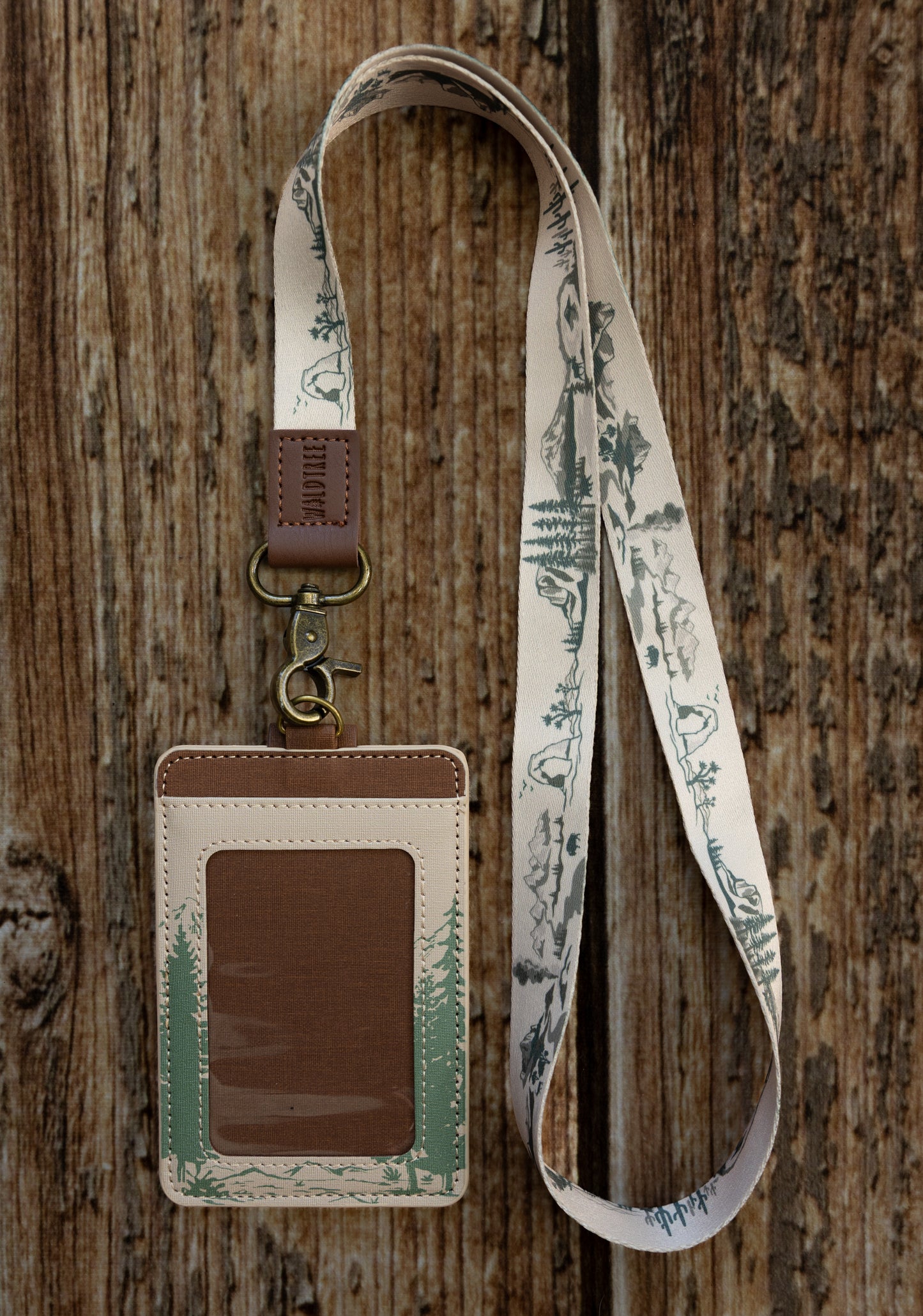 A close-up lifestyle shot showcasing the back details of the Yosemite card wallet while being worn on a lanyard. It highlights the premium texture of the cream synthetic leather and the secure brown button strap overlaying the card slots.