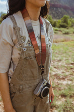 Load image into Gallery viewer, women in field standing with Retro striped camera strap hanging from women&#39;s neck holding film camera
