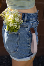 Load image into Gallery viewer, Women with flowers in back pocket and pink rose cloud wristlet keychain hanging out of front pocket
