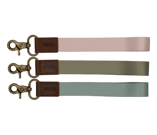 image of three wristlet keychains with bronze hook hardware. pink, green and blue