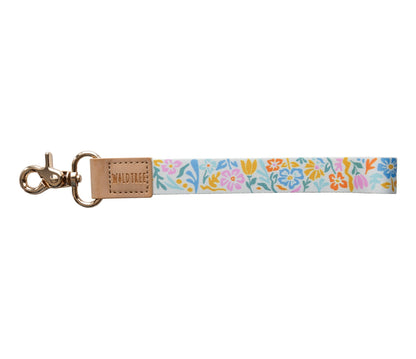 Floral printed wristlet keychain with gold hardware hook. Bright colored flowers