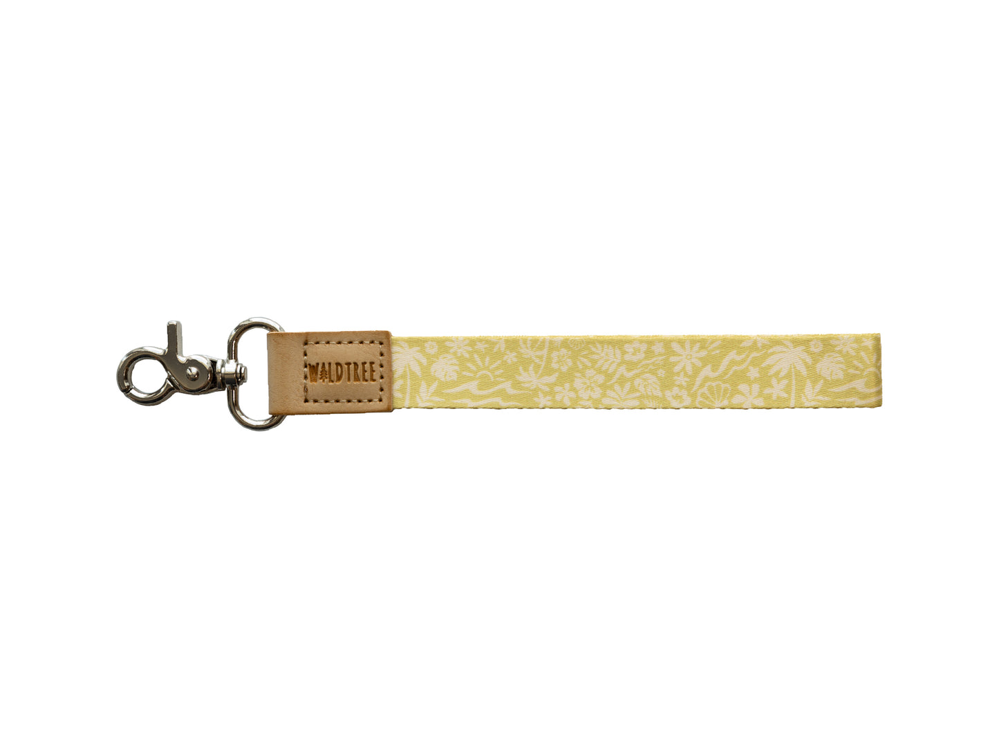 Flat lay of the Sunny Day wristlet keychain on a white background, showing the yellow strap printed with a white beach-themed pattern of waves, palm trees, suns, flowers, and seashells, a tan vegan-leather tab embossed with the WILDTREE logo, and a silver swivel clasp.