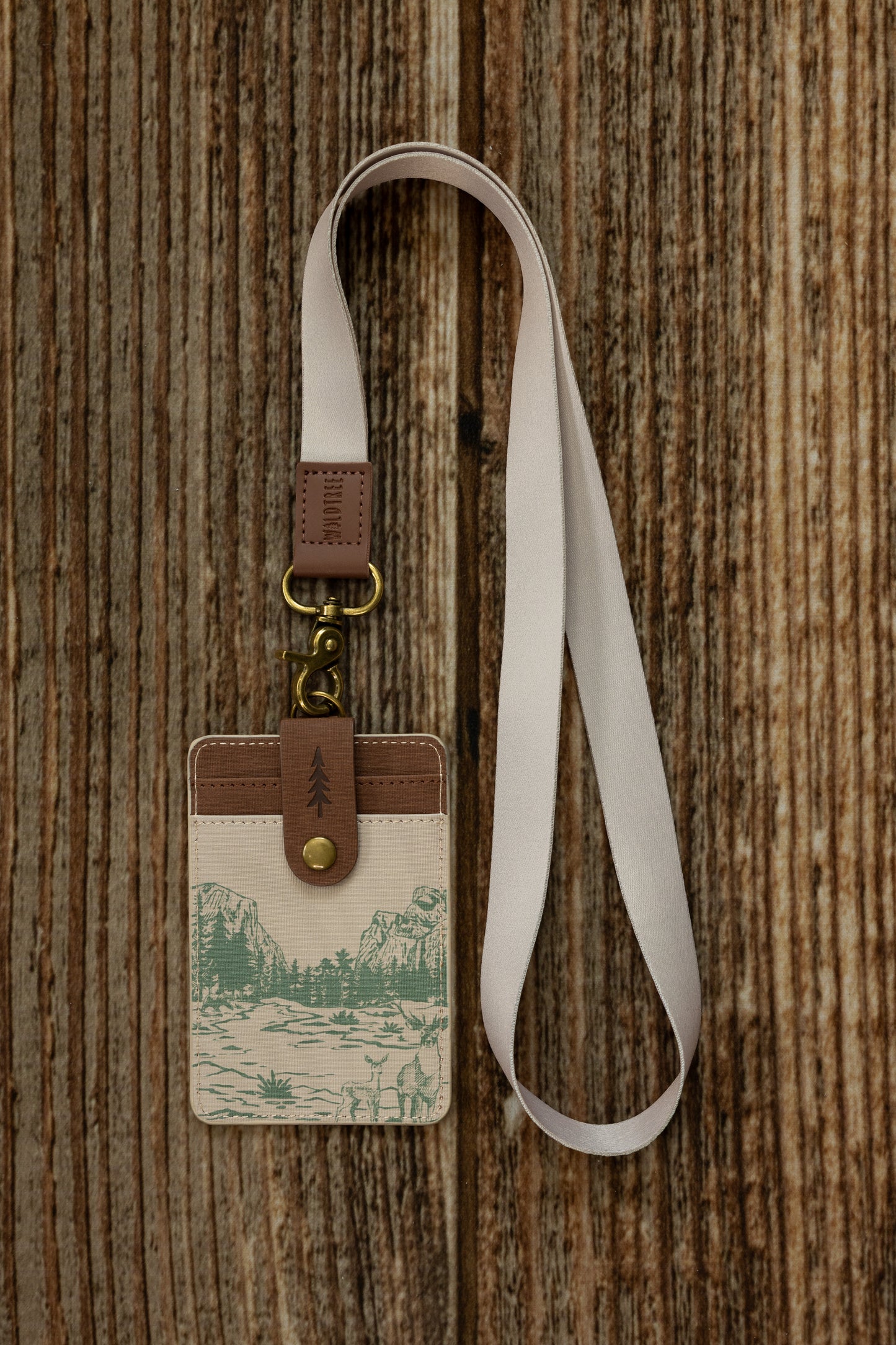 Close-up of the Tan Neck Lanyard's bronze swivel hook and brown vegan leather patch