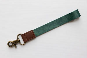 Tropical printed green wristlet keychain with brown leather ends and bronze hook