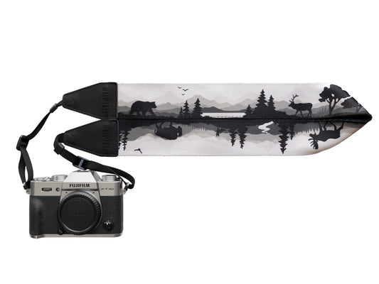 Wildtree Wildlife Camera Strap featuring Bear, Moose and Trees with mountain range background connected to Canon film camera