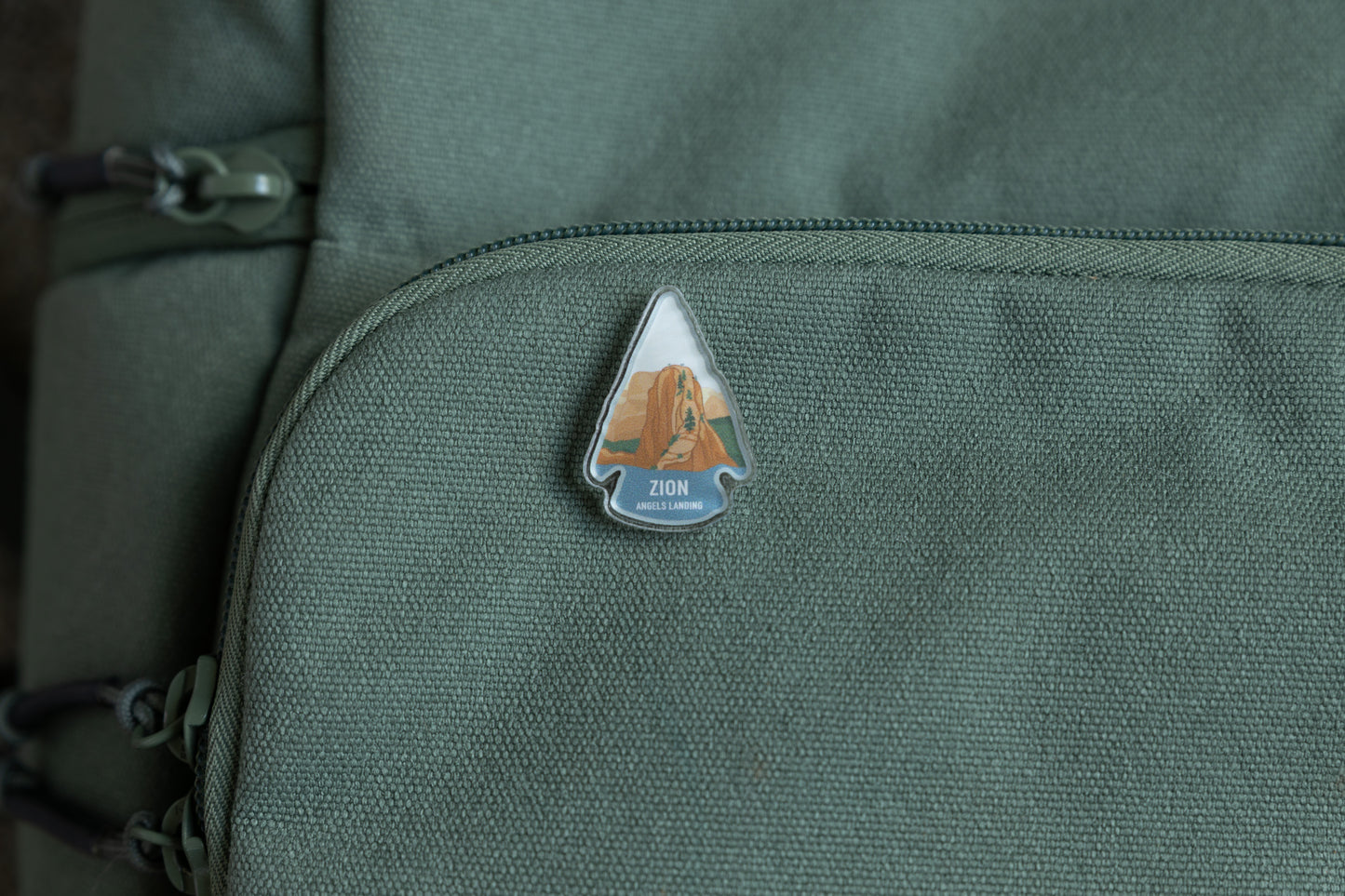 Zion angels landing acrylic pin on green back pack 