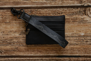 black with printed mountains and stars keychain attached to wallet