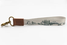 Load image into Gallery viewer, national park wristlet keychain with brown leather ends and bronze hook, featuring 11 national parks
