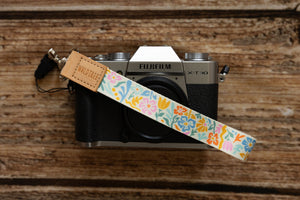 Summer floral wristlet keychain with silver hook attached to vintage Fujiflm camera