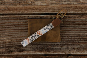 wildflower floral keychain attached to brown leather wallet