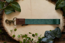Load image into Gallery viewer, Tropical printed green wristlet keychain with brown leather ends and bronze hook

