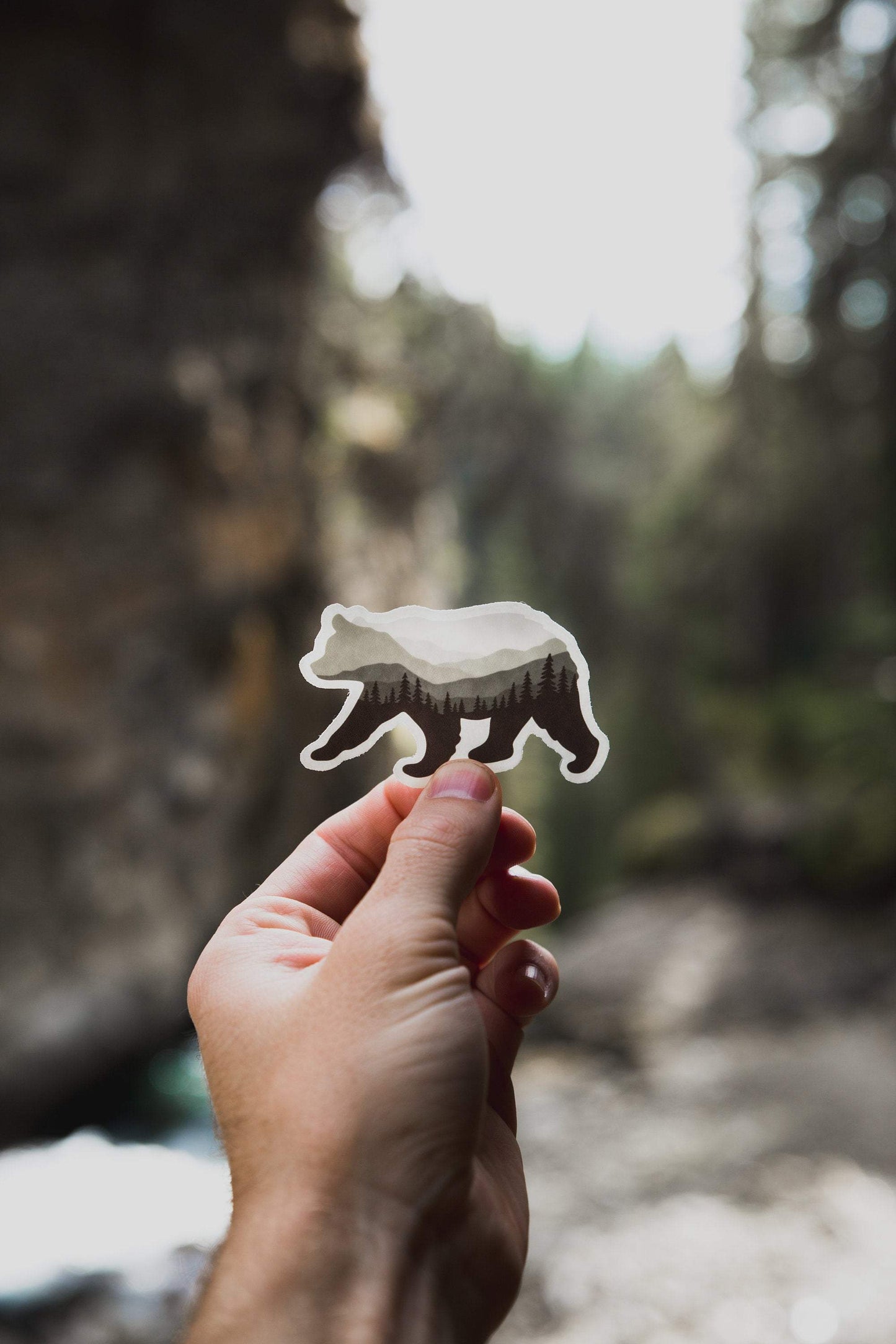 Hand holding Bear Landscape Sticker with mountains and trees