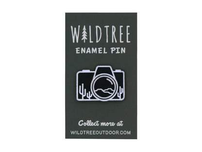 Camera shaped enamel pin with desert mountains and cacti on enamel pin green backing 