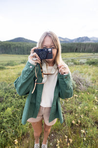 Women wearing wildtree daisy floral camera strap pointing camera at you