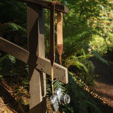 Load image into Gallery viewer, Wildtree Dune Camera Strap hanging from hand rail in woods
