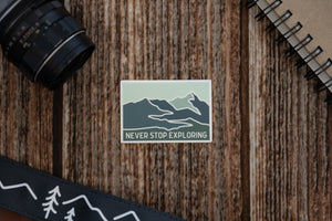 Never Stop Exploring Sticker on wood background
