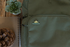 Wildtree park ranger hat pin displaying words "Respect our Parks" pinned to backpack