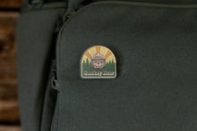Load image into Gallery viewer, Smokey bear acrylic pin on green backpack
