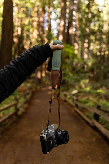 arm extended out holding Wildtree Sequoia camera strap connected to film camera