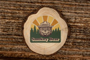 Smokey Bear sticker laying on wood