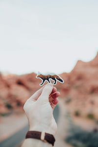 hand holding fox sticker with tree and desert hills