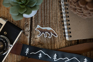 fox landscape sticker Sticker on wood background surrounded by notebook, camera and succulent