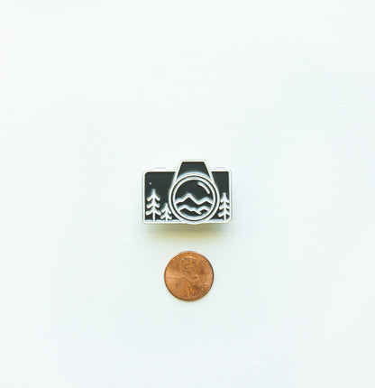 Camera pin next to penny for size comparison