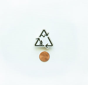 Recycle logo redesigned incorporating a mountain and tree next to penny for size comparison 