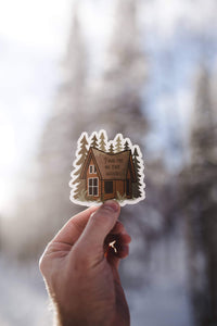 hand holding Find me in the woods cabin sticker