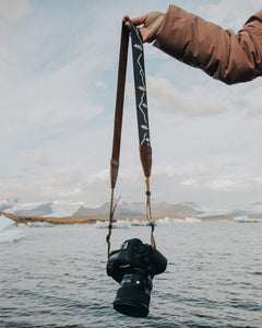 extended out arm holding Wildtree Camera strap attached to Canon DSLR camera