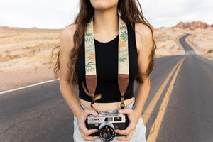 women wearing Wildtree camera strap wild desert around neck standing in VOF road