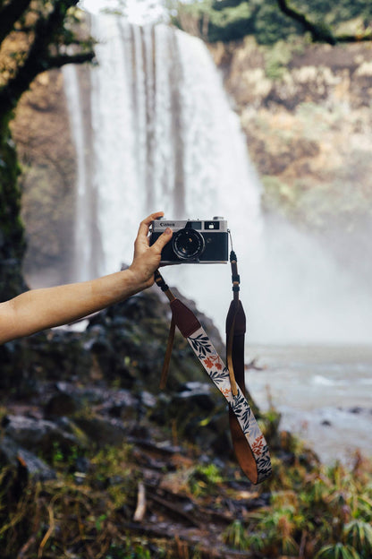 extended hand holding film camera with Wildtree Wildflower Floral camera strap attached